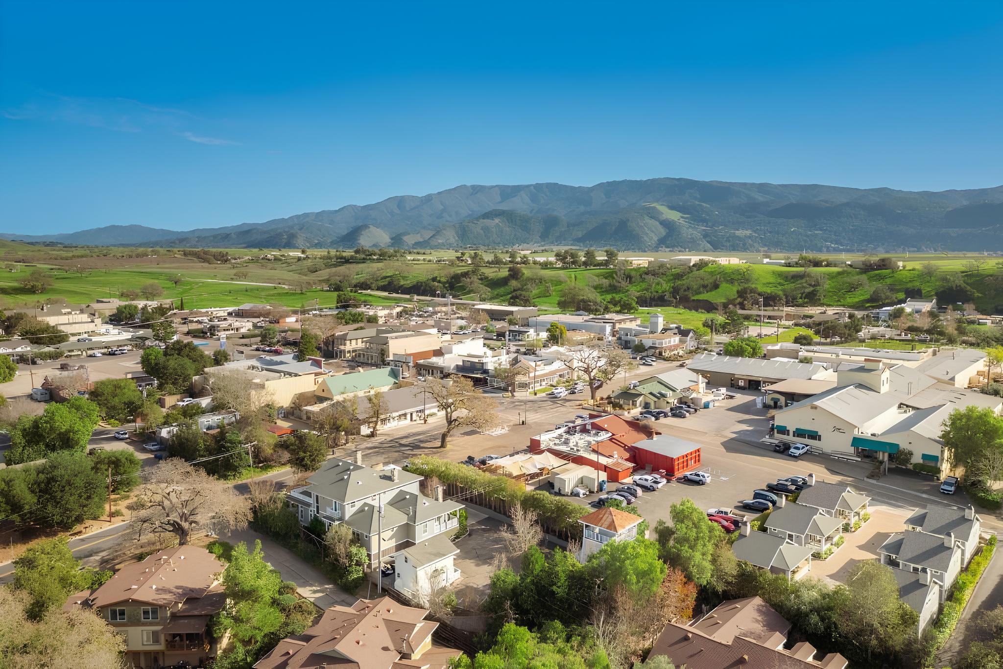 An aerial view of the town of Santa Ynez, the valley's green hills and the Santa Ynez Mountains behind it