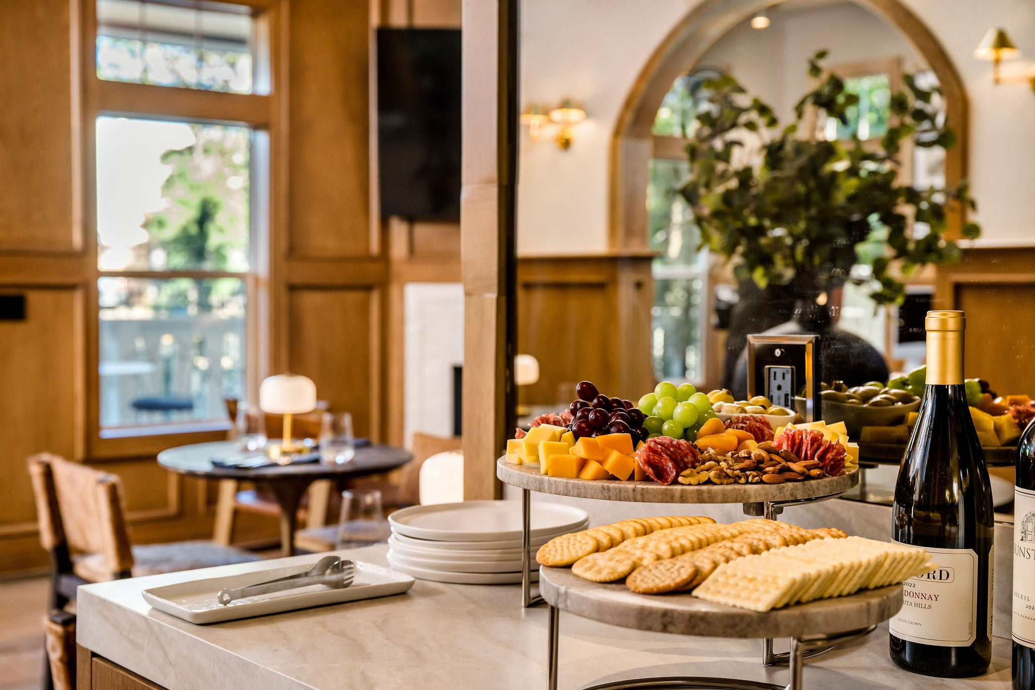 A spread of cheese, charcuterie, fruit, and crackers with wine at The Polo House