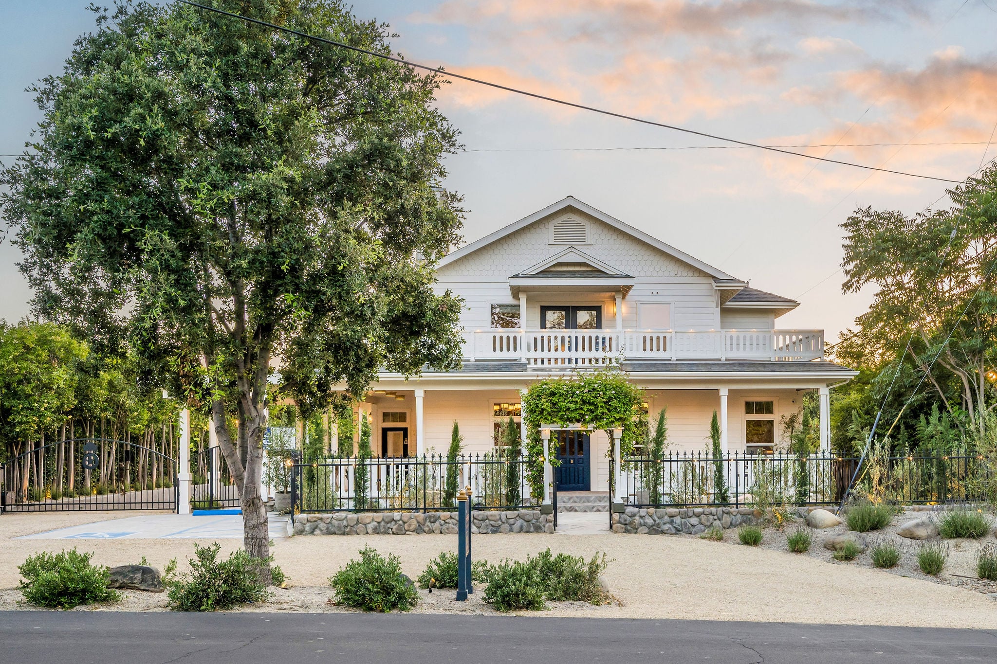 The Polo House today, restored white farmhouse with wraparound porch at dusk