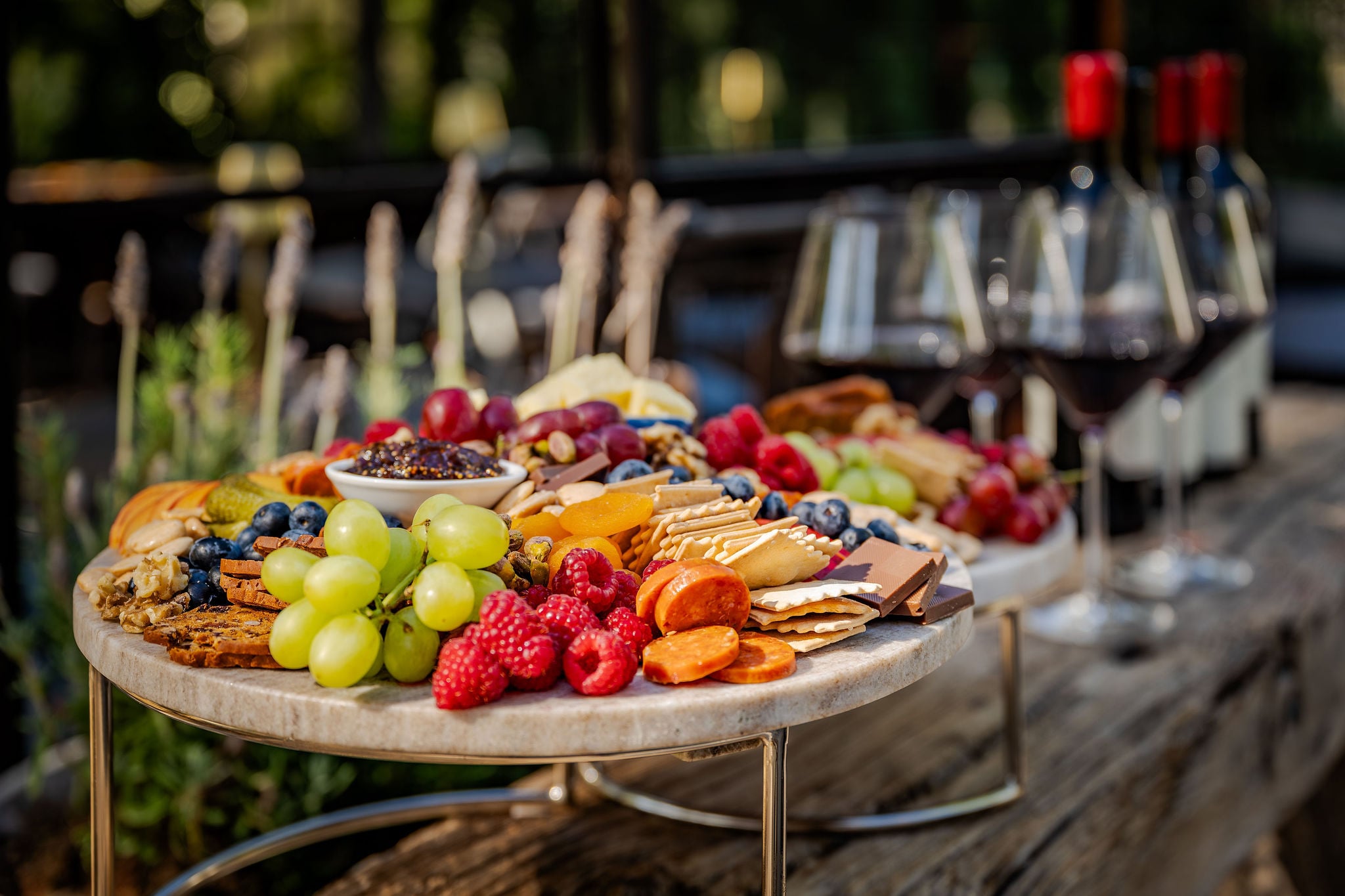 A charcuterie board with fruit, cheese, and glasses of local red wine at The Polo House Aperitif
